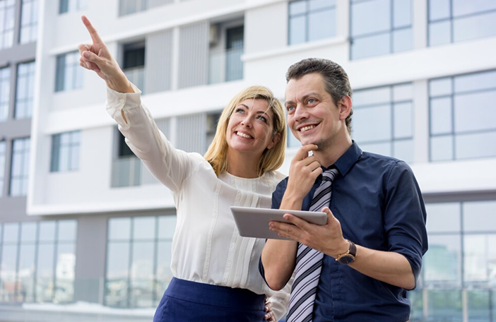 happy-lady-pointing-showing-male-colleague-something-outdoors_1262-12522 1